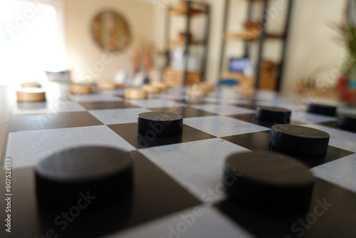 Side view of checkers board game in room with no one. photo