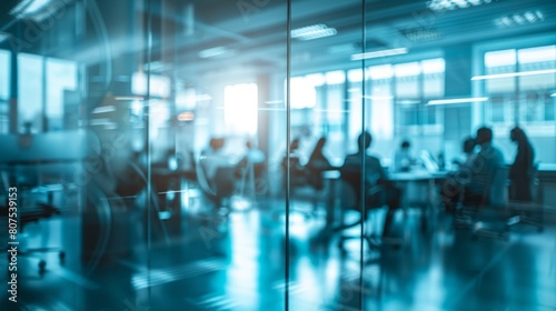 Blurred offices with people working behind glass walls