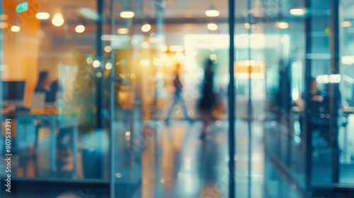 Blurred offices with people working behind glass walls