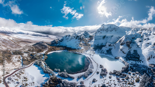 Scenery of high mountains with lakes and snow-capped peaks. Snow landscape on winter mountain and lake.