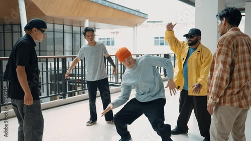 Professional hipster performing hip-hop footstep surrounded by multicultural friend. Hipster group clap hands and encourage professional break dancer show street dance. Outdoor sport 2024. hiphop. photo
