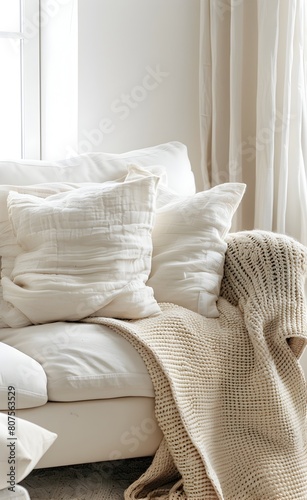 Beige sofa with a beige blanket and pillows in a minimalistic interior of a modern living room with Scandinavian home decor