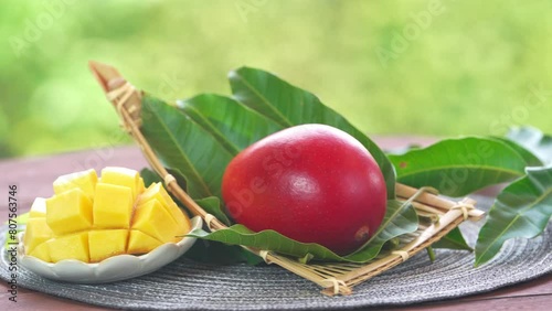 Red mango in Bamboo basket on green bokeh background, Fresh Japanese Elegant mango fruits “Egg of the Sun” Sugar content of 16 degrees on wooden background.