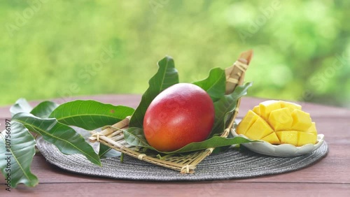 Red mango in Bamboo basket on green bokeh background, Fresh Japanese Elegant mango fruits “Egg of the Sun” Sugar content of 16 degrees on wooden background.
