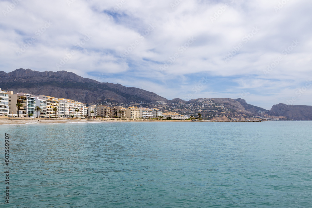 Photo of the beautiful beach in Altea, Alicante in Spain showing hotels and restaurants on the beach front by the pebble beach known as Playa La Roda