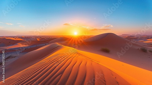 Desert landscape bathed in the soft light of dawn  with the sun rising over the horizon 