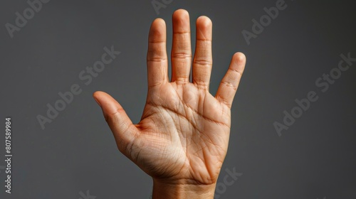 Stop Gesture, One hand up with palm facing forward, signaling 'stop' or setting a boundary. photo