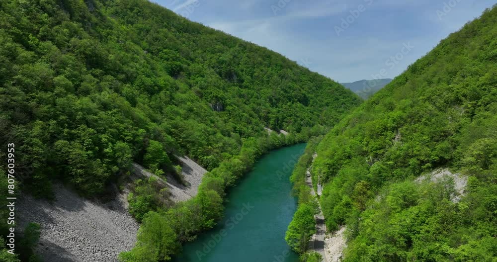 A tranquil river surrounded by new greenery under a blue sky with a few clouds, viewed from a low-flying perspective. A tranquil river surrounded by new greenery under a blue sky with a few clouds, viewed from a low-flying perspective.
