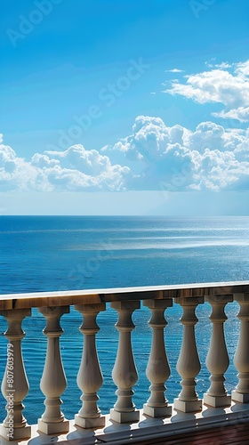 A balcony overlooks the vast expanse of the ocean, offering a peaceful and breathtaking view of the waves rolling in under the clear blue sky