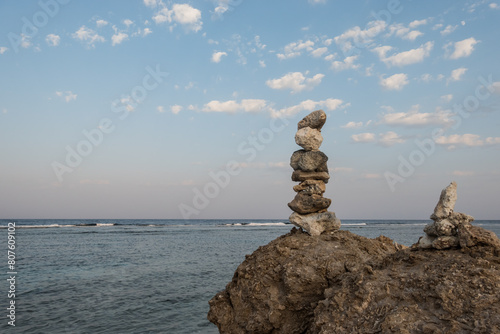 stacked corals at the beach with view to the sea and sky with white clouds