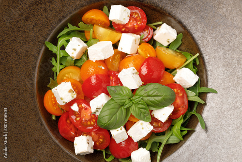 a bowl of salad with tomatoes and cheese