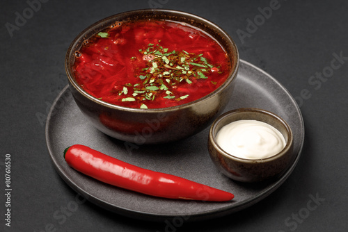 a bowl of soup with a chili pepper and a red pepper
