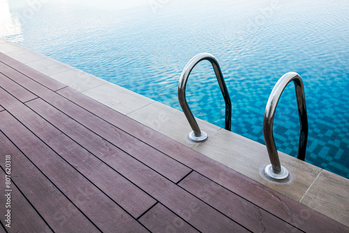 Swimming pool handrails and ladder. Blue pool water. Healthy lifestyle. Swimming sports