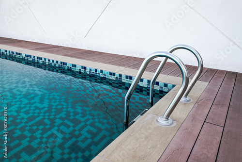 Swimming pool handrails and ladder. Blue pool water. Healthy lifestyle. Swimming sports