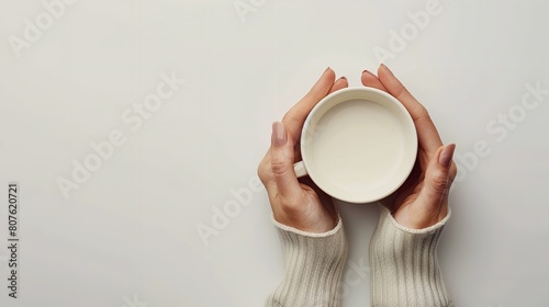 A top view of female hand holding empty cup over plain white backdrop for a mockup or product advertisement backdrop with a big space  Generative AI.