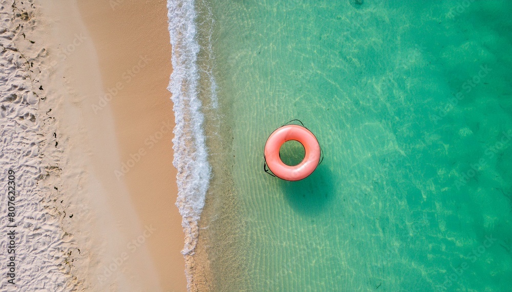 Naklejka premium An emerald beach with a swimming float on it. a summer recreation site, drone shot - Swim ring, swim&nbsp;tube, Tube&nbsp;Ring