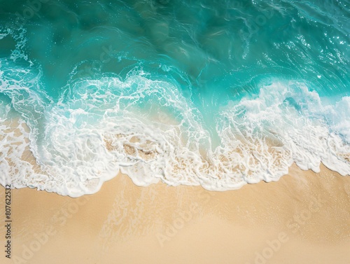 Aerial perspective of sandy beach as ocean wave rolls in