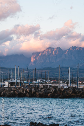 Sunset light hitting the Hottentots holland mountains with Gordons bay harbor in the forefront photo