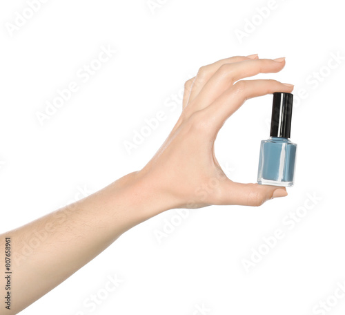 Woman holding nail polish on white background, closeup