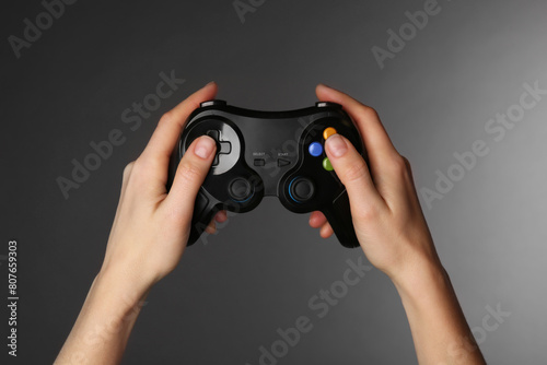 Woman with game controller on grey background, closeup