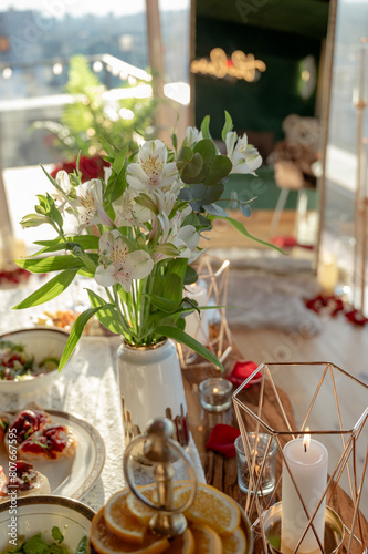 Vase with flowers on the table. romantic dinner.holidays, dinner party and holiday concept - close-up of festive table