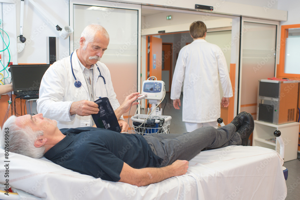 Obraz premium male doctor measuring the blood pressure of a senior man