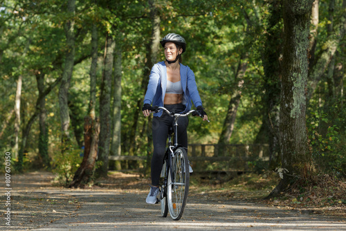 happy young beautiful woman riding sport mountaine bicycle in forest photo