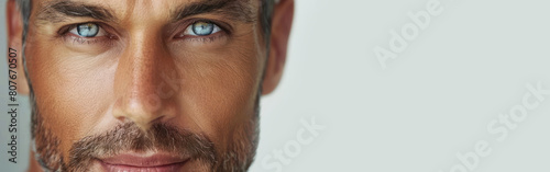 Close-up of a young man with striking blue eyes staring intensely at the camera photo