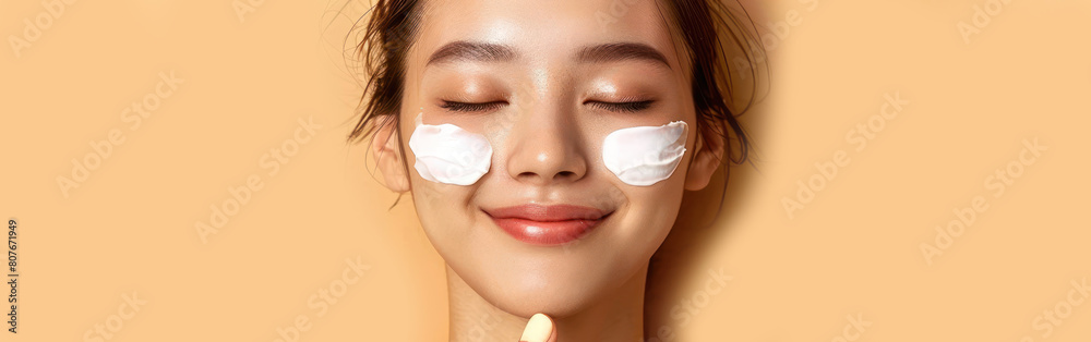 A woman holding a tube of cream over her face, applying it gently with her fingers A woman holding a tube of cream over her face, applying it gently with her fingers