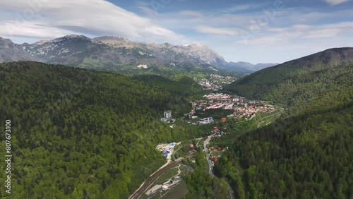Travel to Romania Carpathian mountain side. Aerial 4k video with Sinaia mountain resort located in Prahova Valley (Valea Prahovei in Romania) at the bottom of Bucegi mountains.  photo