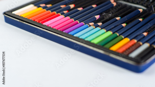 Set of color pencils with different size in pencil case on a white background