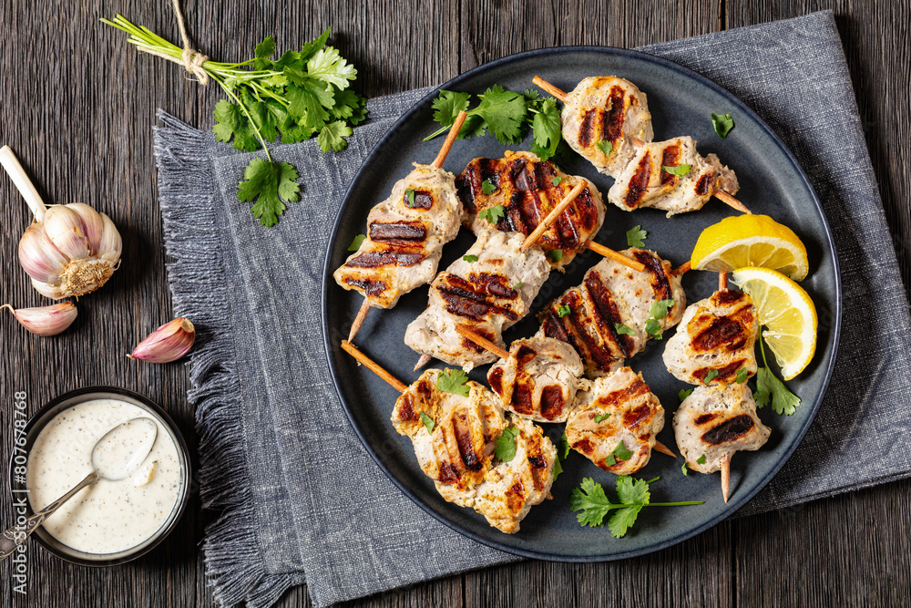 grilled mini pork skewers on a plate, top view grilled mini pork skewers on a plate, top view