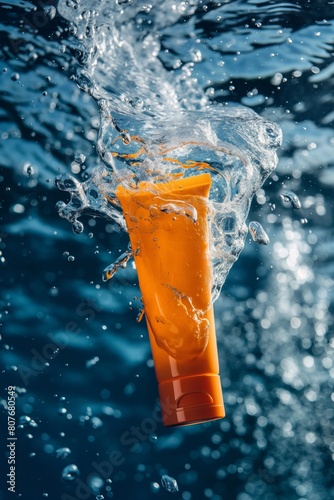 Vibrant orange tube splashing dramatically into deep blue water