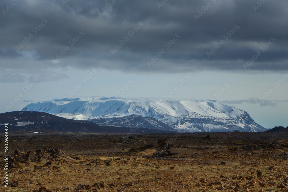 Barren landscape and snow covered mountain of northern Iceland Barren landscape and snow covered mountain of northern Iceland