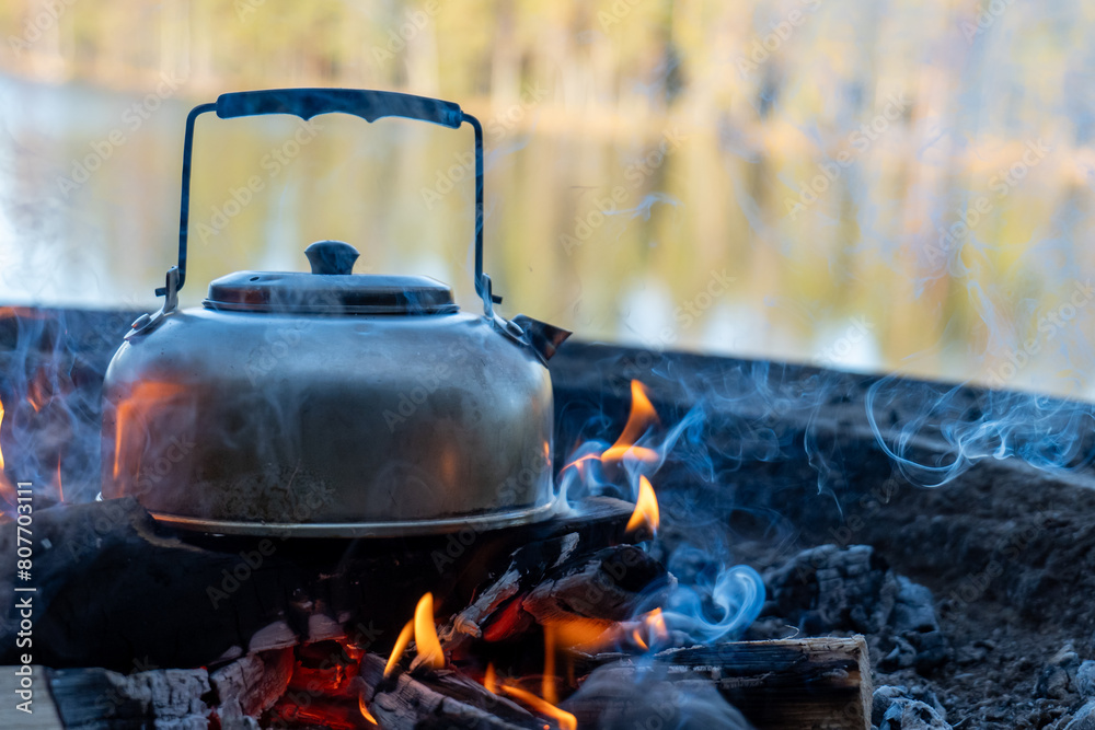 Camp kettle is heated on a bonfire. Hiking concept. Camp kettle is heated on a bonfire. Hiking concept.
