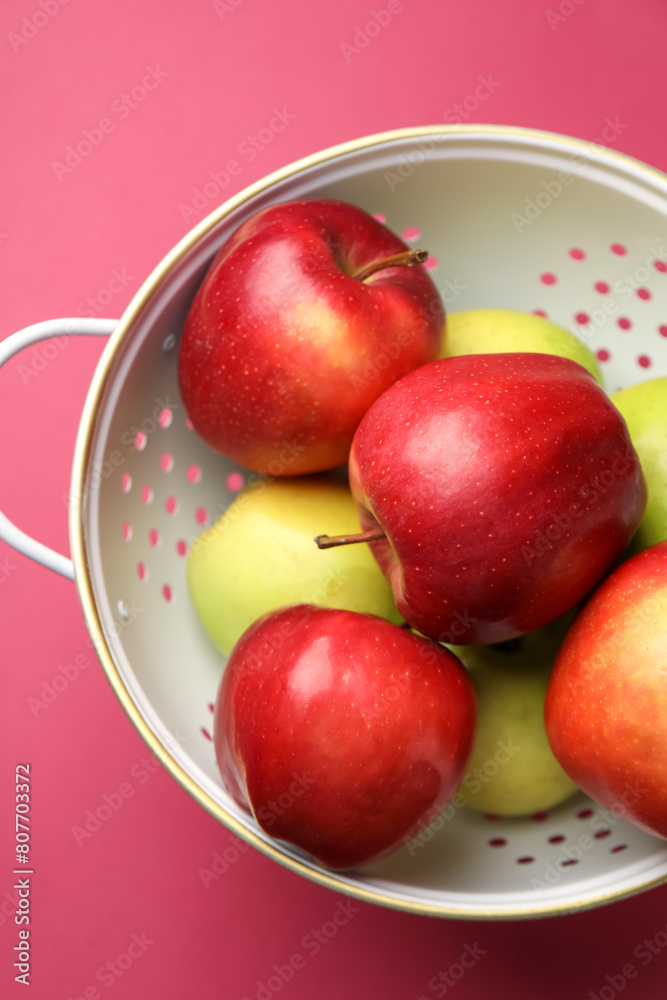Colander with fresh apples on pink table, top view Colander with fresh apples on pink table, top view