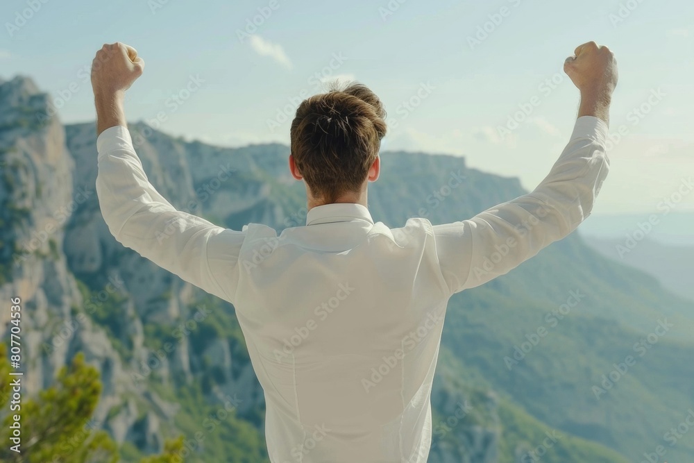 Man Celebrating on Mountain Top with Arms Raised, Victory, Freedom, Outdoor Adventure Man Celebrating on Mountain Top with Arms Raised, Victory, Freedom, Outdoor Adventure