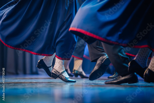 a close-up of dancers' feet during a Latvian folk dance, showcasing movement and traditional attire details.