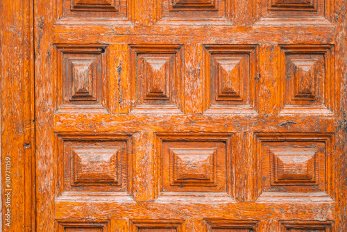 Vintage wooden door with peeling orange paint