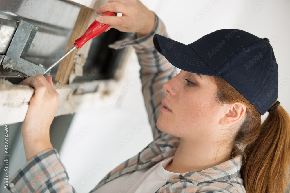 young woman working on window seal