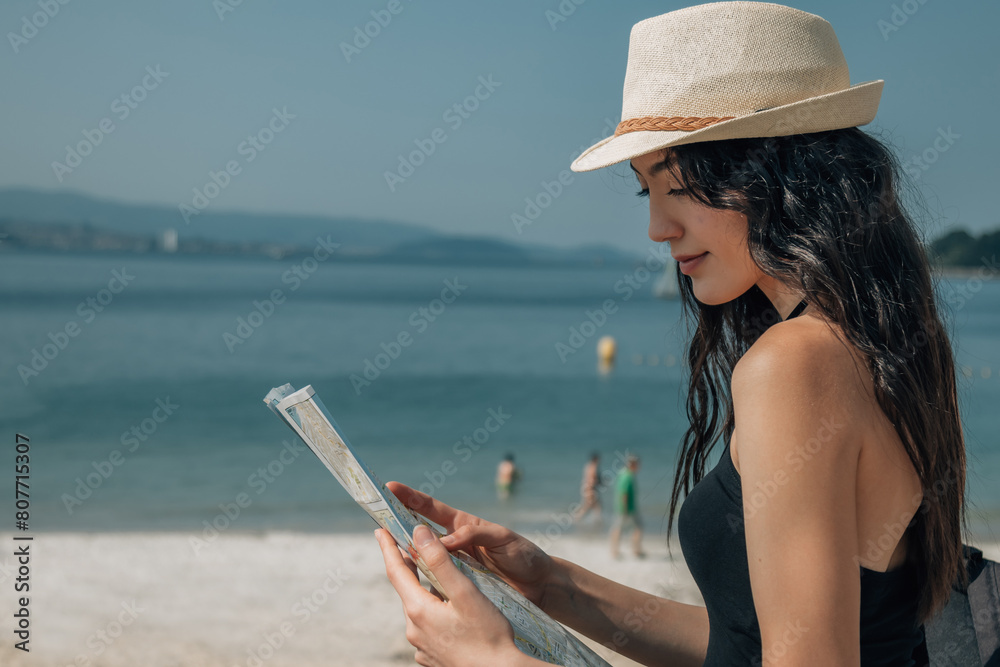 young tourist woman looking at the map with beach background