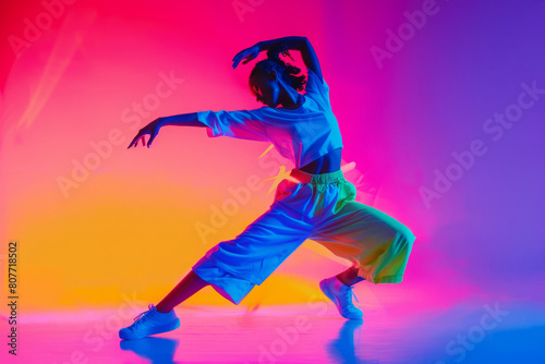 Female dancer on neon colored background. Woman in dynamic pose dancing, showing artistic expression