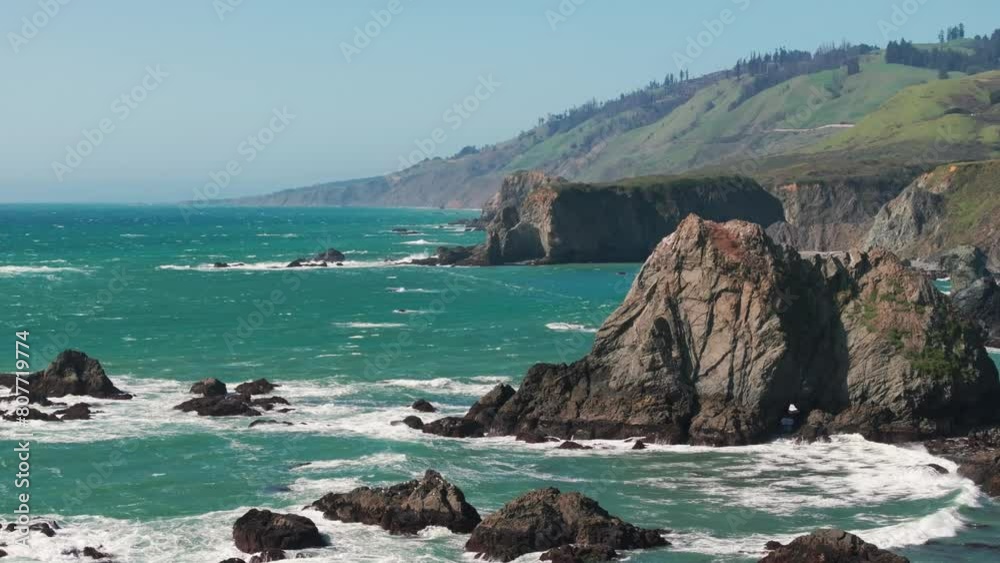 Static drone shot of waves crashing into the steep rock walls of northern California Static drone shot of waves crashing into the steep rock walls of northern California