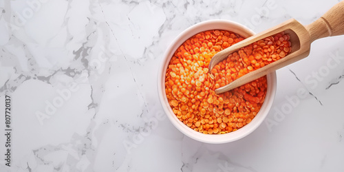 Bowl of lentils and spoon on white marble. photo