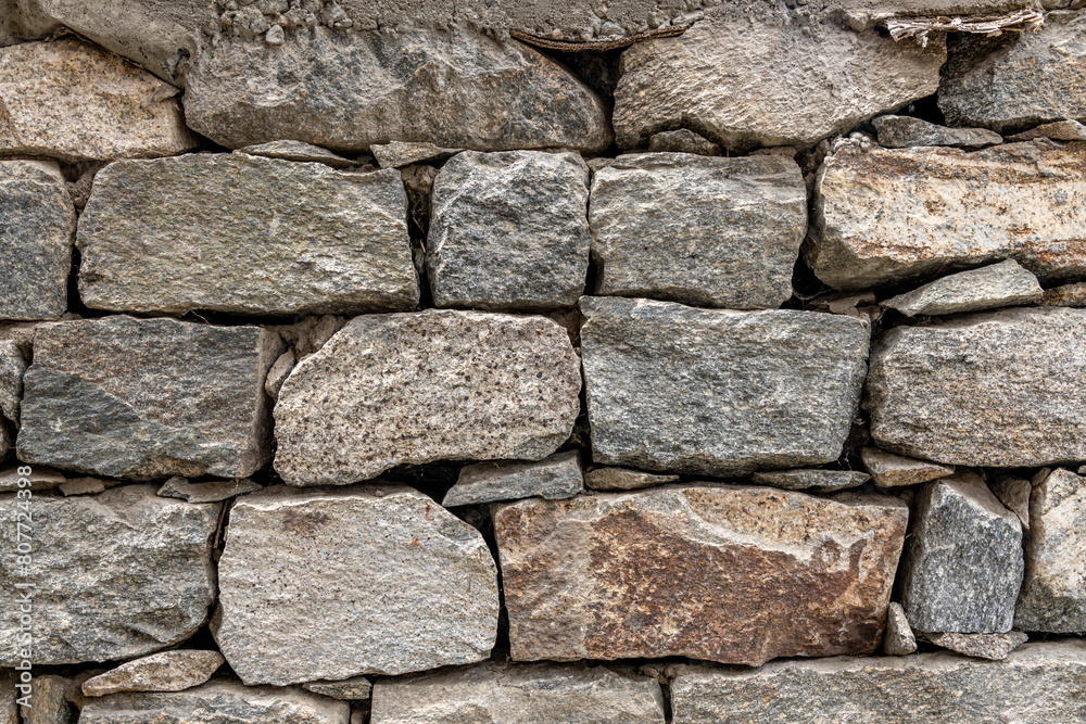 Stone wall made up of different sizes, shapes and colors of field rocks