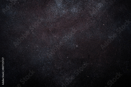 Black painted concrete texture or background with shadow and grain elements. High contrast and resolution image with place for text. Template for design