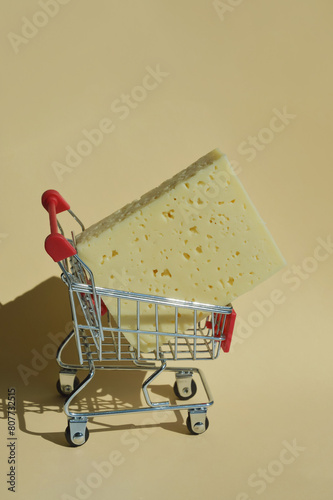 The cheese is in the shopping cart. selling food in the store. background for the design. dairy product