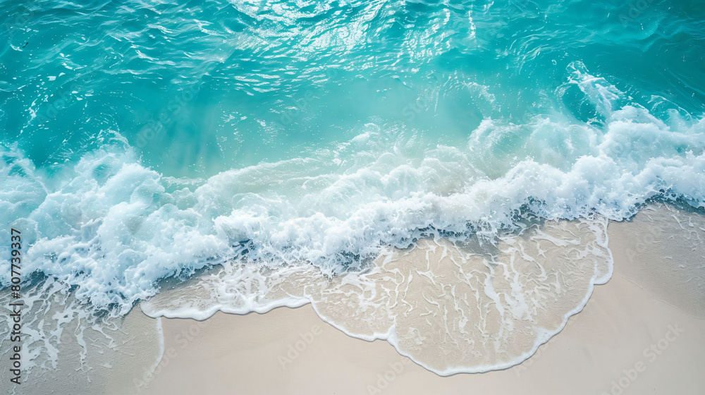 Clean ocean waves breaking on white sand beach