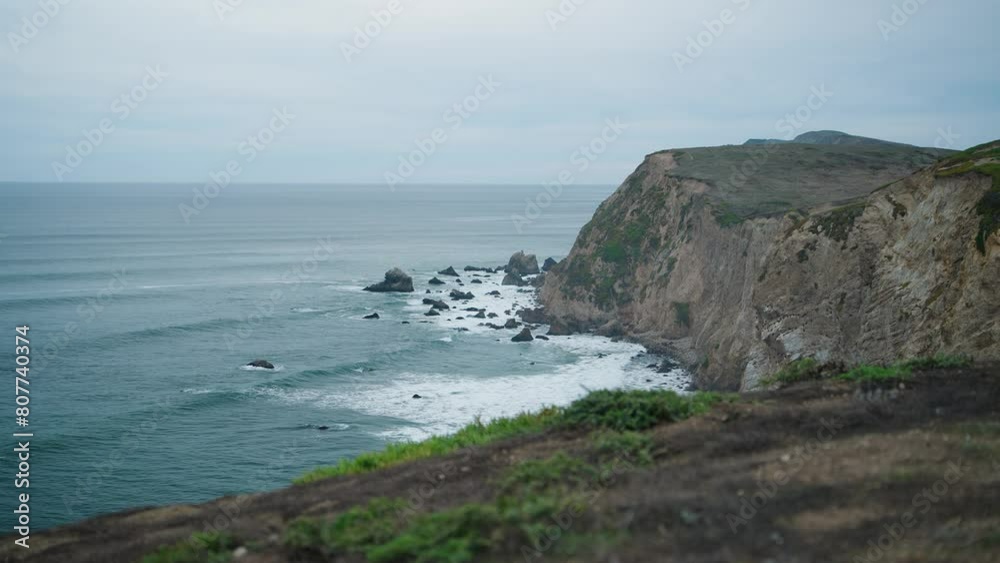 Waves crashing into a steep cliff in northern California on a gloomy day Waves crashing into a steep cliff in northern California on a gloomy day