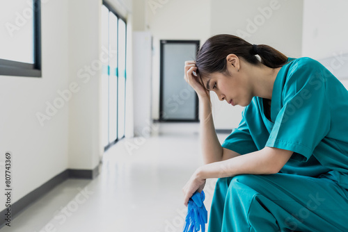 Asian female nurse feeling depress with hospital work photo